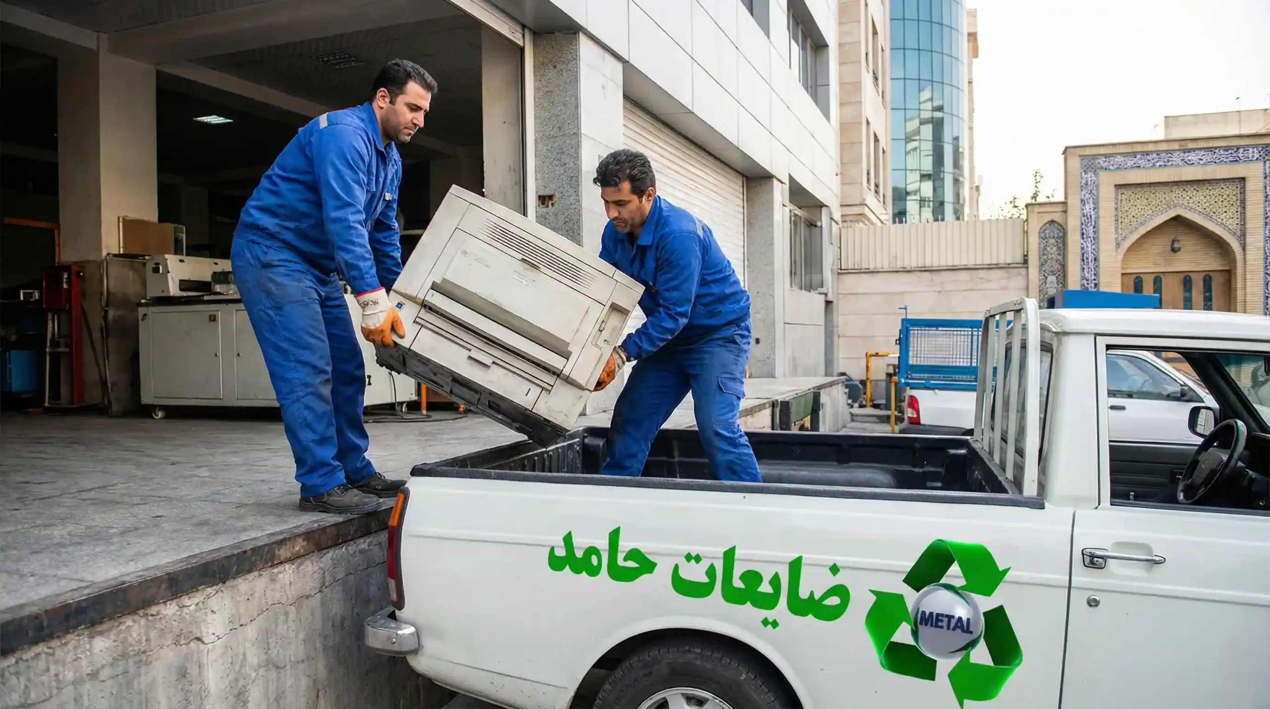 کارگران ایرانی در حال بارگیری ضایعات لوازم اداری و کامپیوتر در کامیون